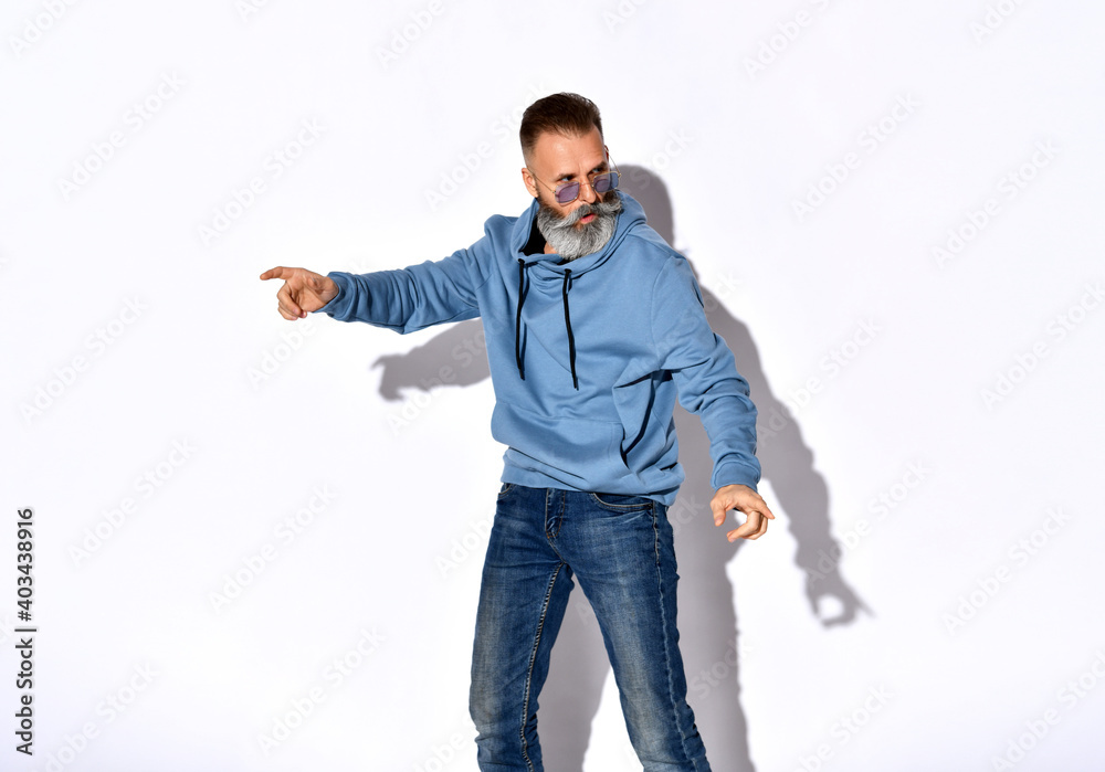 Wall mural frowning bearded man wearing trendy sunglasses, casual sweatshirt, fashion jeans denim standing look