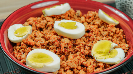 A closeup of Desi pakistani and indian chicken keema with boiled eggs pieces on the top.