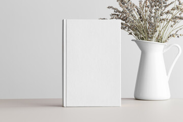White book mockup with a bouquet of a lavender on a beige table.