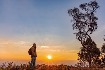 Hipster male hiker with backpack enjoying sunset mountain. Tourist traveler on background view mockup.