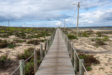 endless long wooden boardwalk in the Ria Formosa National Park on the Algarve