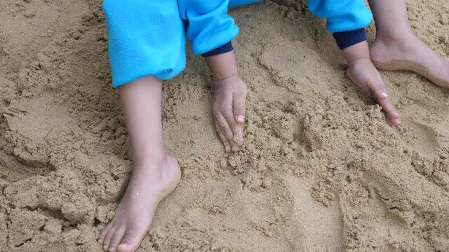 4K Child's hand playing sand outdoor in summer. Concept of family activity, learning with playing.