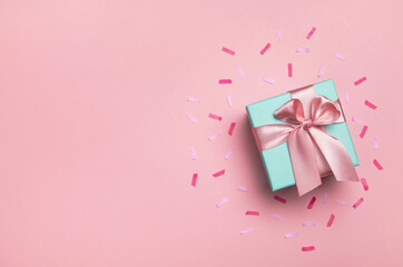 Gift box and confetti on pastel pink background. Birthday party, Valentines day or mother day...