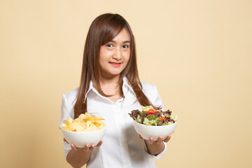 Young Asian woman with potato chips and salad.