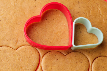Dough for making heart shaped cookies on Valentines Day. Homemade pastry. Red and green plastic baking molds.