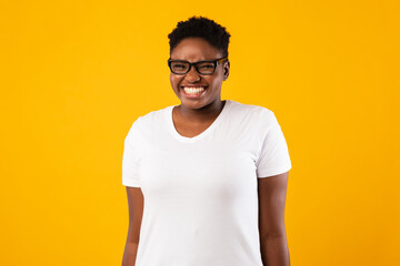 Positive Plus-Size Black Lady Smiling Standing Over Yellow Background