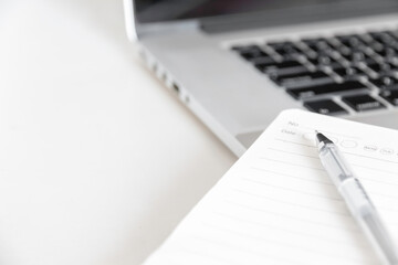 close up laptop and notebook on a desk with space for copy text.