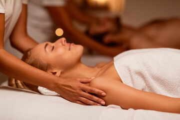 Obraz na płótnie Canvas Woman Enjoying Massage During Couples Beauty Treatment Lying At Spa