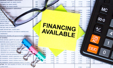 Text Financing Available on yellow stickers with calculator, eyeglasses and paper clips