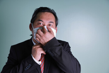 Close up of face Asian businessman wears a black suit looking at the camera has high self-confidence wearing medical masks are to prevent coronavirus.