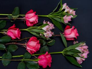 Bouquet of fresh scarlet roses and red Alstroemeria in a black background