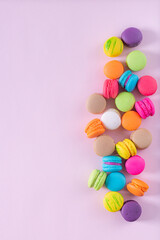 Row of colorful french macarons on pink background. Top view. Pastel colors