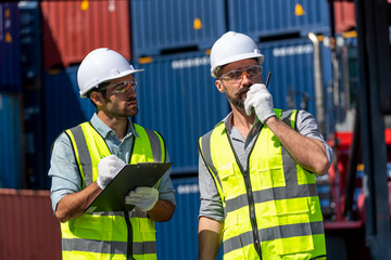 Logistics engineer and inspector working togetter and discussing in shipping containerin commercial transport port