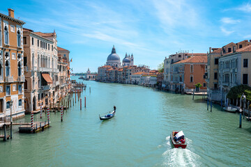 Fototapeta na wymiar Paesaggio a Venezia sul Canal Grande e la Basilica Santa Maria della Salute. Gondola che naviga sul Canal Grande.