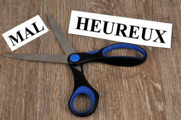 Concept de malheureux et heureux avec un mot coupé avec des ciseaux