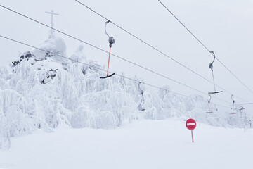 prohibitory road sign No entry against the background of an empty ski surface lifts on a snowy ski slope