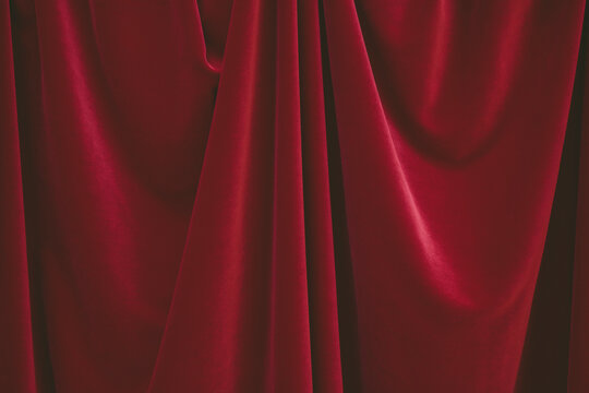 Detail of draped red velvet curtain with folds and creases