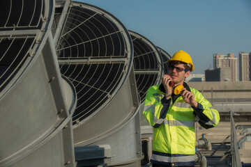 service technician is using a radio on the cooling tower. worker, Engineer  using a radio...