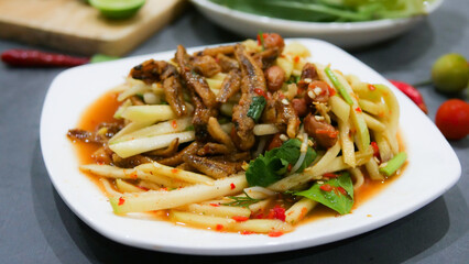 Yum, mango photo top views Food arrangement. Spicy salad food, topped with fried nuts and crispy fish. The main ingredients are raw mango, lime juice, fresh chili powder, fish sauce, sugar to mix.