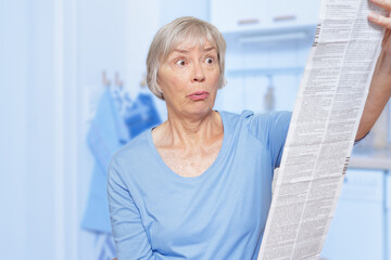 Shocked senior woman with an enormous patient user information sheet for her prescribed medicine.