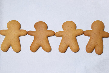 gingerbread men in a row on parchment for baking
