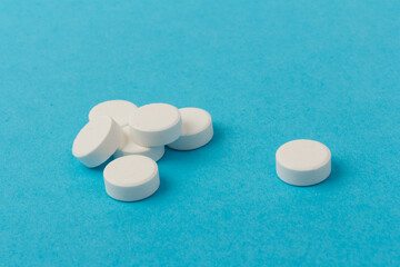 Heap of pills on blue background. Medicine, pharmacy and health concept.