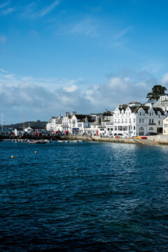 View along the seawall and facades of houses in Saint Mawes, Cornwall, UK.