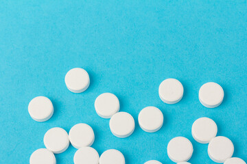Heap of pills on blue background. Medicine, pharmacy and health concept.