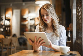 young woman in a cafe with a tablet