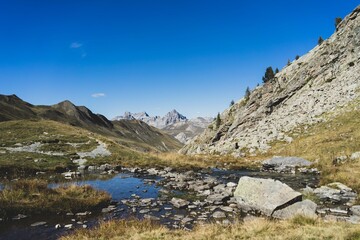 Lac du Lauzanier dans les Alpes de haute provence, avec les montagnes à l'horizon.