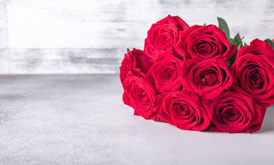 Horizontal banner with bouquet of red roses on stone background. Valentines day greeting card