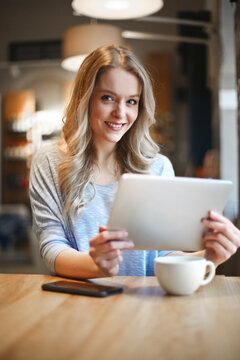 young woman in a cafe with a tablet