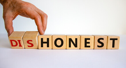 Honest or dishonest symbol. Businessman hand turns cubes and changes the word 'dishonest' to 'honest'. Beautiful white background. Business and honest or dishonest concept. Copy space.