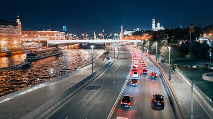 Fototapeta premium MOSCOW – OCTOBER 4, 2020: View of the Moskva River from the Bolshoi Moskvoretsky Bridge on a late autumn evening, full moon in the sky behind the clouds. 