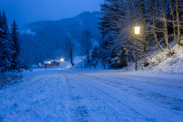 Frozen winter landscape with icy road and street lantern on the countryside in the Austrian alps (Filzmoos, Salzburg county)