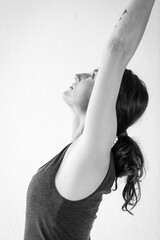 Naklejka premium Side view detail of brunette woman stretching, doing the standing asana Crescent Lunge Pose - Anjaneyasana