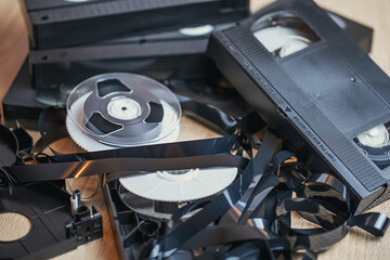 A disassembled old video cassette with a film lies on the table. Outdated technology.