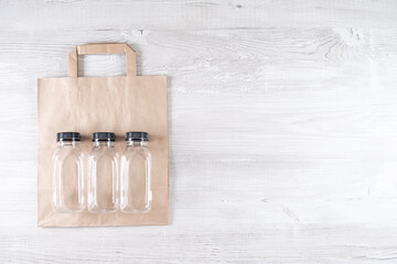 paper bag, three plastic bottles. place for your logo. Eco-friendly food packaging and cotton eco bags on gray background with copy space. Carering of nature and recycling concept. containers for