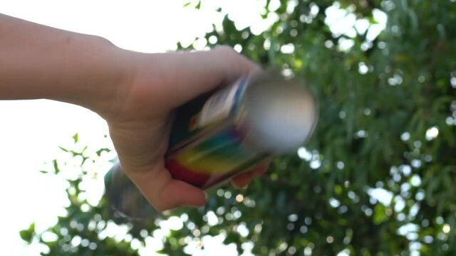 Close up shot of hand shaking a spray paint bottle