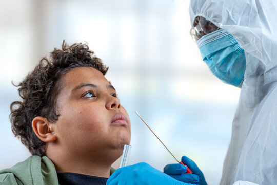 scientist doctor in protection suit working at laboratory holding up new vaccine bottle