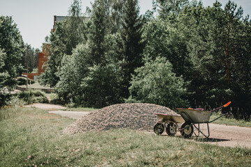 Two wheelbarrows standing near pile of gravel