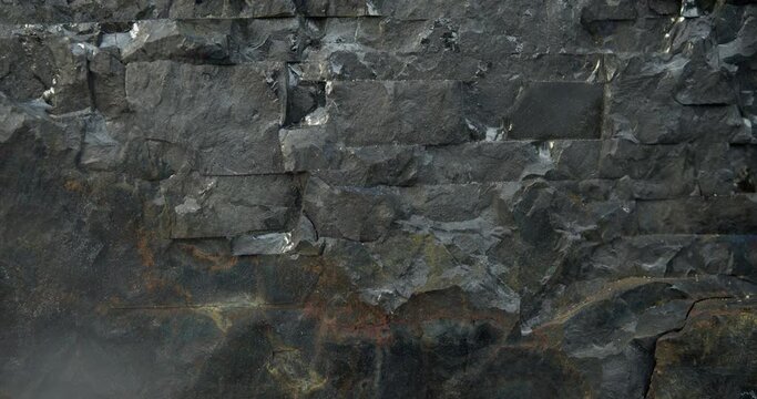 Dark gray background. A black stone wall that looks like a huge fantasy rock.