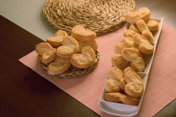 Palms of puff pastry on white rectangular plate and wicker plate