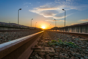 railway in the countryside and sunset, Railroad and station, On the sides are lighting poles ( Lamppost ), railway