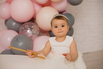 Fototapeta na wymiar Baby girl at first birthday with smash cake