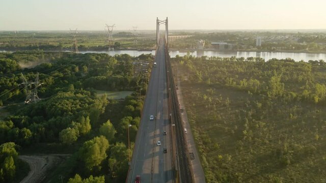 Aerial shot flying over cars crossing Zarate Brazo Largo bridge at golden hour