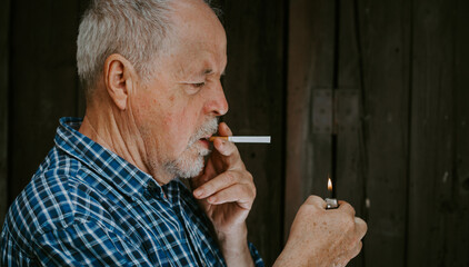 An old senior man smoking a cigarette outside, smoke addiction, bad habbit