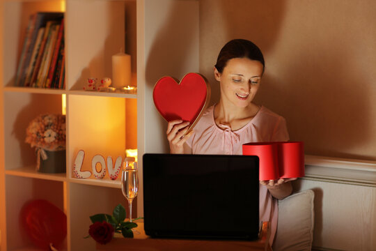 The girl communicates via video link with her beloved and opens the received gift in the evening in a dim light