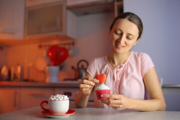 A girl in love prepares cupcakes for a loved one for Valentine's Day.