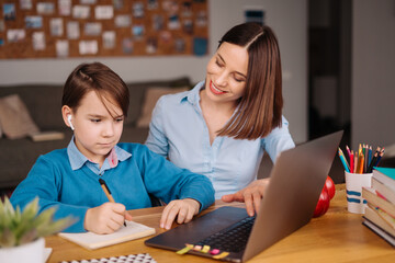 A Preteen boy uses a laptop to make a video call with his teacher. The Screen shows an online lecture with a teacher explaining the subject from class.